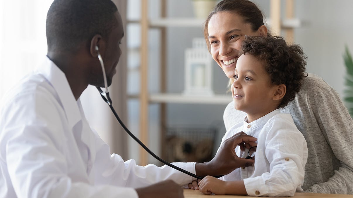 Doctor listening to boy's heart with stethoscope
